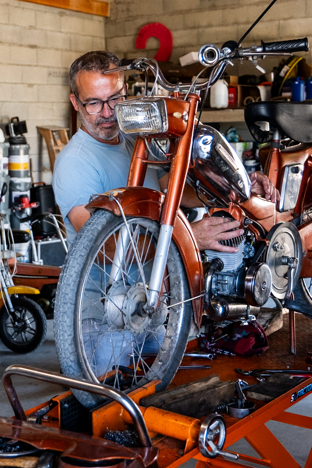 Portrait de Franck, L'échappée Brelle qui prépare une mobylette pour la location